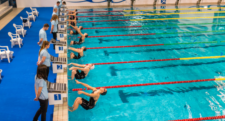 Swim team competitors on their mark for backstroke