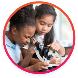 Private school students in science lab using microscope