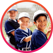 Boys youth baseball team members standing by a fence