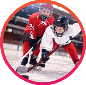 Youth hockey players reaching for the puck in a match