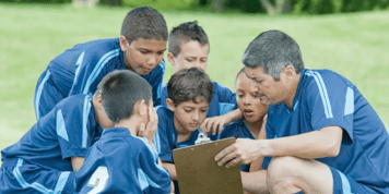 Youth sports team gathered in a huddle to review a play