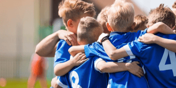 Youth sports team huddling together before a game