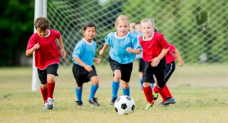 Youth soccer team running down the field with the ball