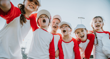 Youth softball team gathered in a huddle
