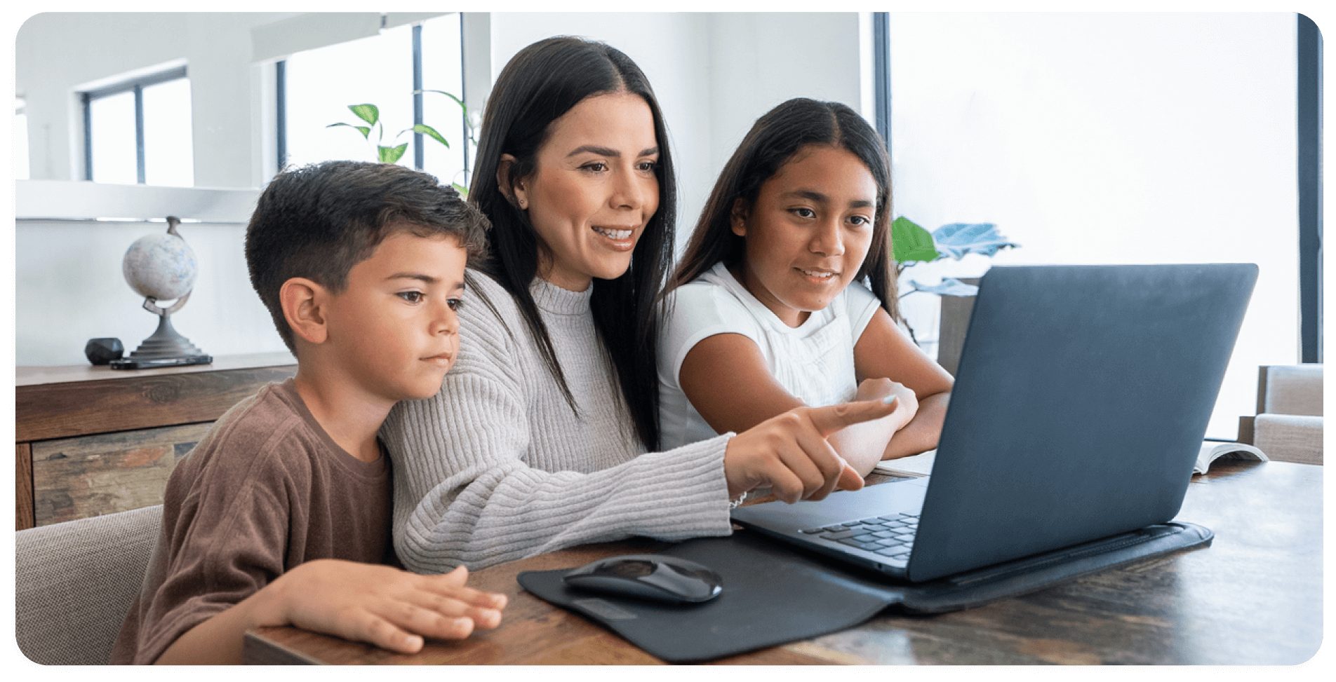 mom with two young kids looking at laptop