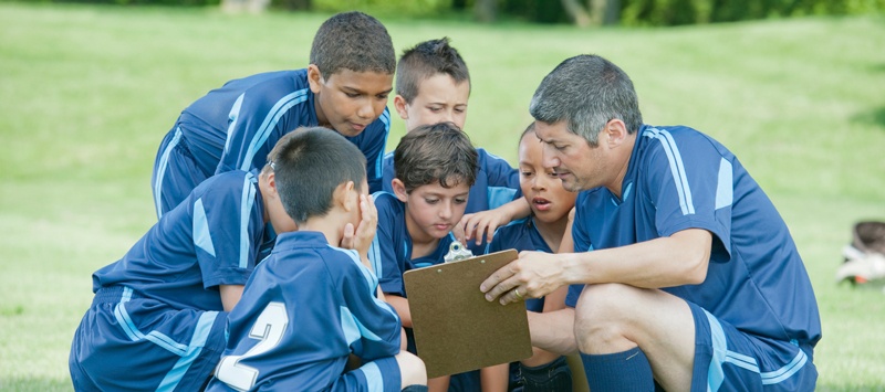 boys soccer team huddled around the coach