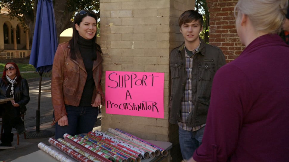 Sarah and Drew from tv show "Parenthood" selling wrapping paper outside of a store for fundraising