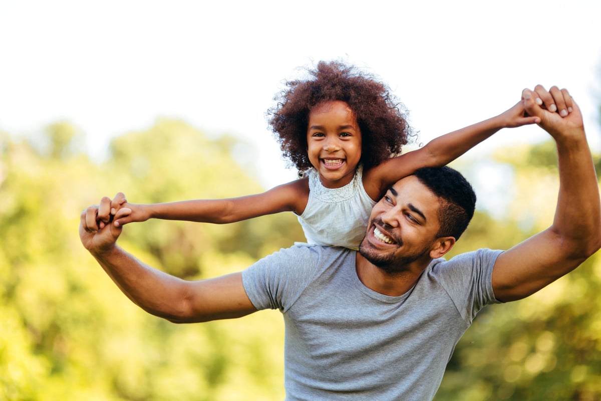 father with young daughter on his back