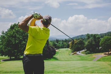 man swinging a golf club at a golf tournament fundraiser