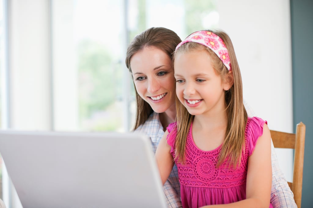Mother and daughter happily working on computer