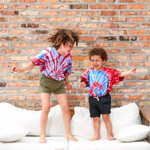 two kids wearing july 4th patriotic tie dye shirts