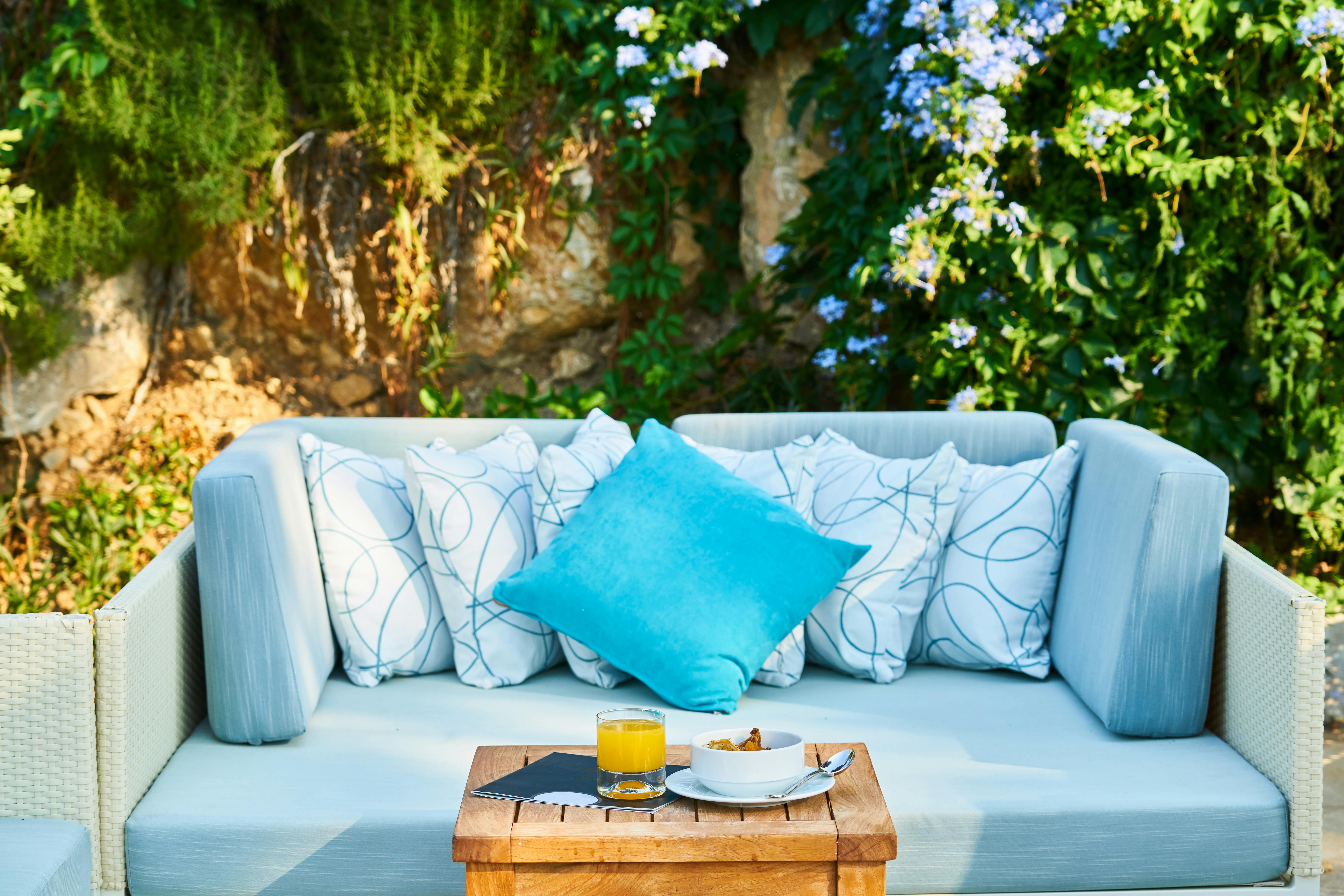 spring-themed outdoor seating with pillows on a bench