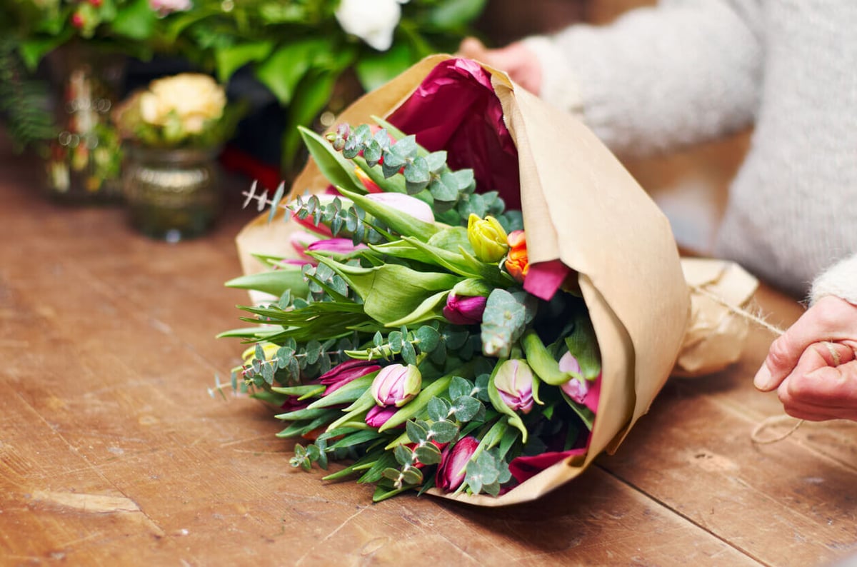 person wrapping flowers for a plant fundraiser
