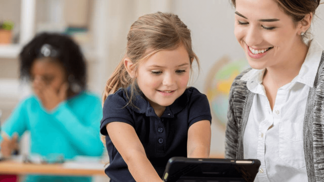 teacher working with student on ipad tablet