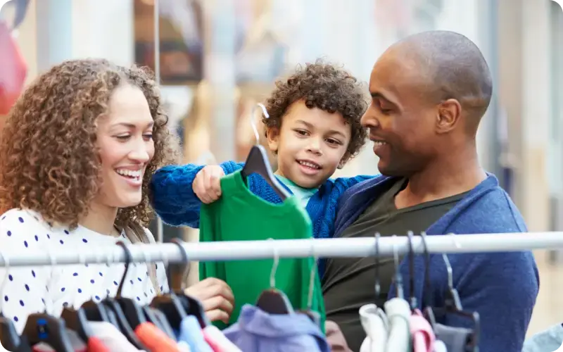 Parents and their child shopping for clothes at a retailer