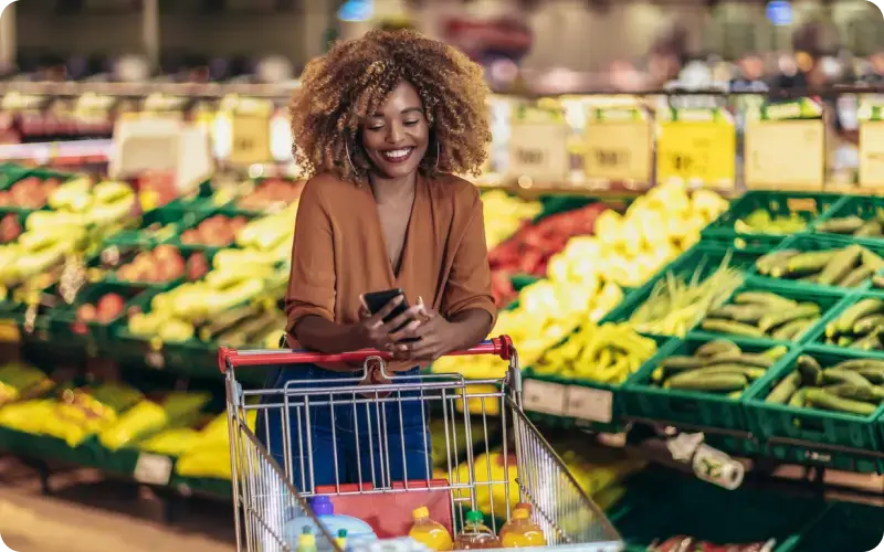 Woman shopping in a grocery store and looking for gift cards