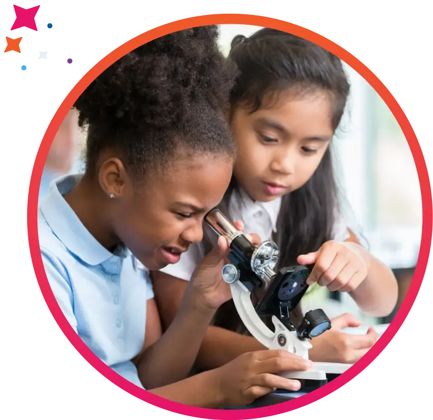 Two students in a private school classroom lab looking into a microscope