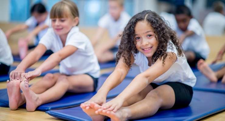 Young gymnasts stretching during practice