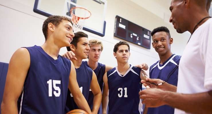 Boys basketball team talking to their coach